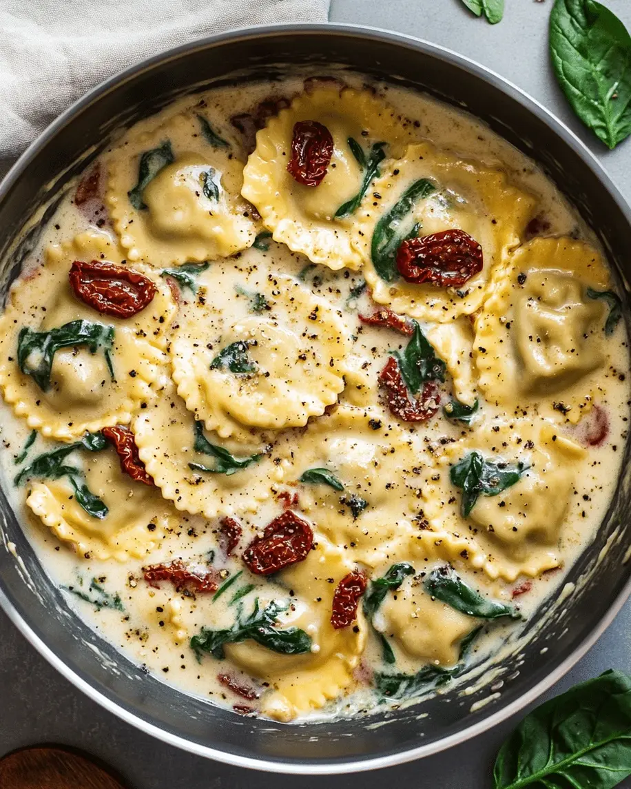 Finished creamy spinach and sun-dried tomato ravioli served in a decorative plate with garnish