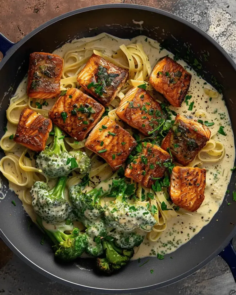 Crispy blackened salmon fillets with steamed broccoli florets in a creamy Alfredo sauce, showcasing the bold flavors and tender textures of Blackened Salmon and Broccoli Alfredo.