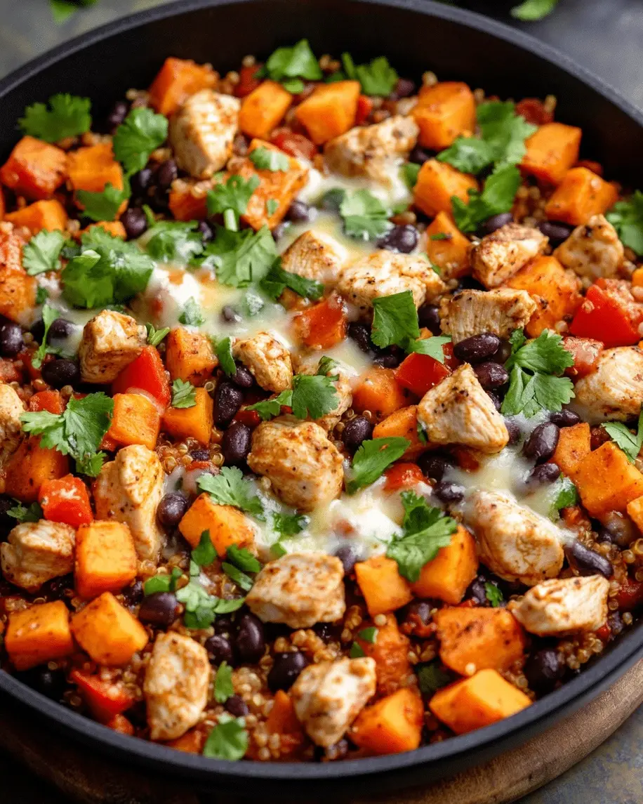 A vibrant chicken and sweet potato skillet sizzling in a cast-iron pan, with colorful veggies and black beans for a delicious one-pan meal.