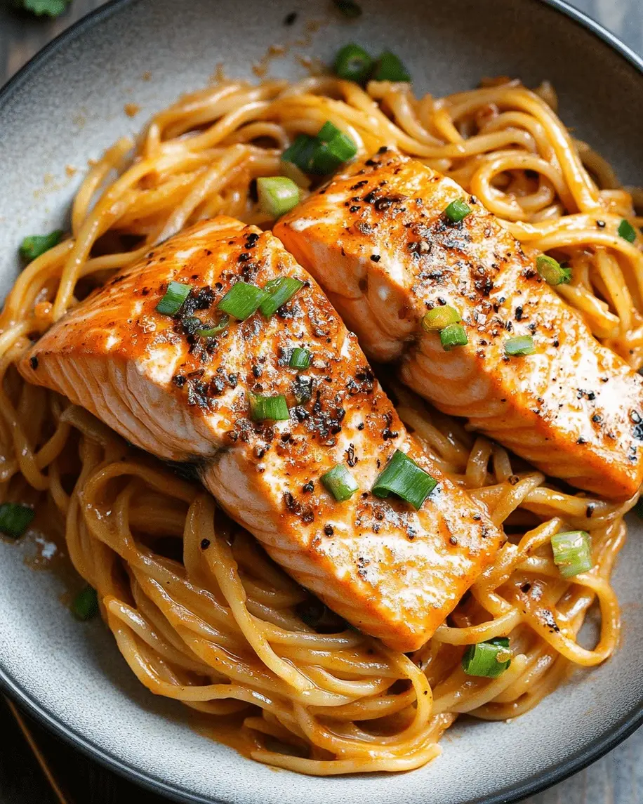 Close-up of seared salmon on creamy garlic noodles