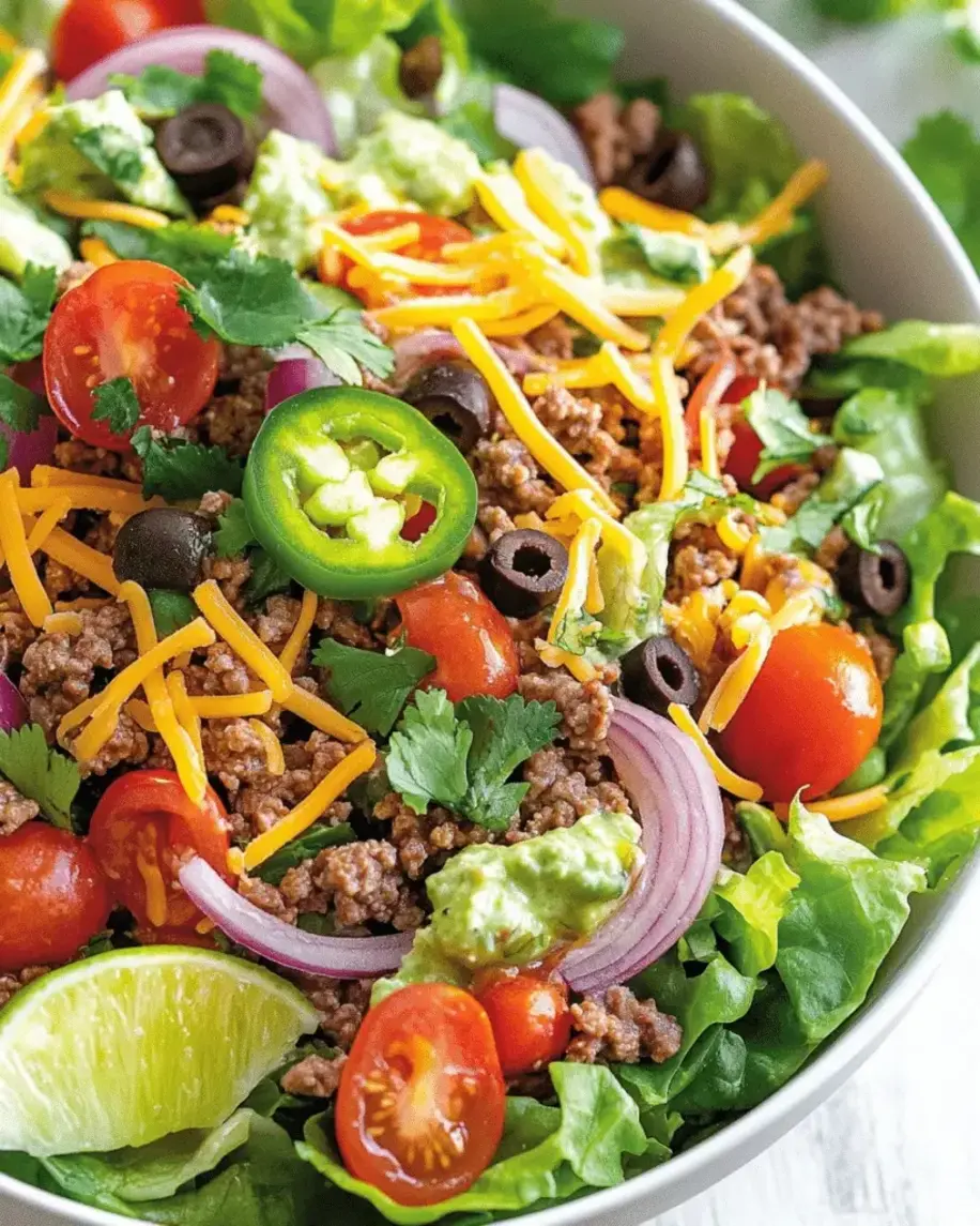 Finished Taco Salad with ground beef, fresh veggies, and dressing in a bowl
